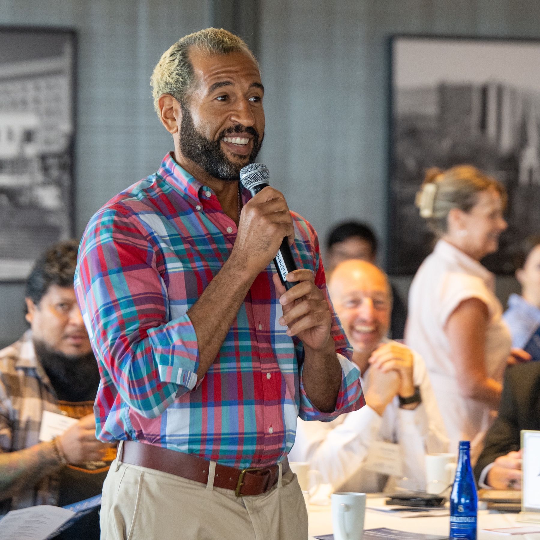Ian Cain laughing mid-talk with a microphone